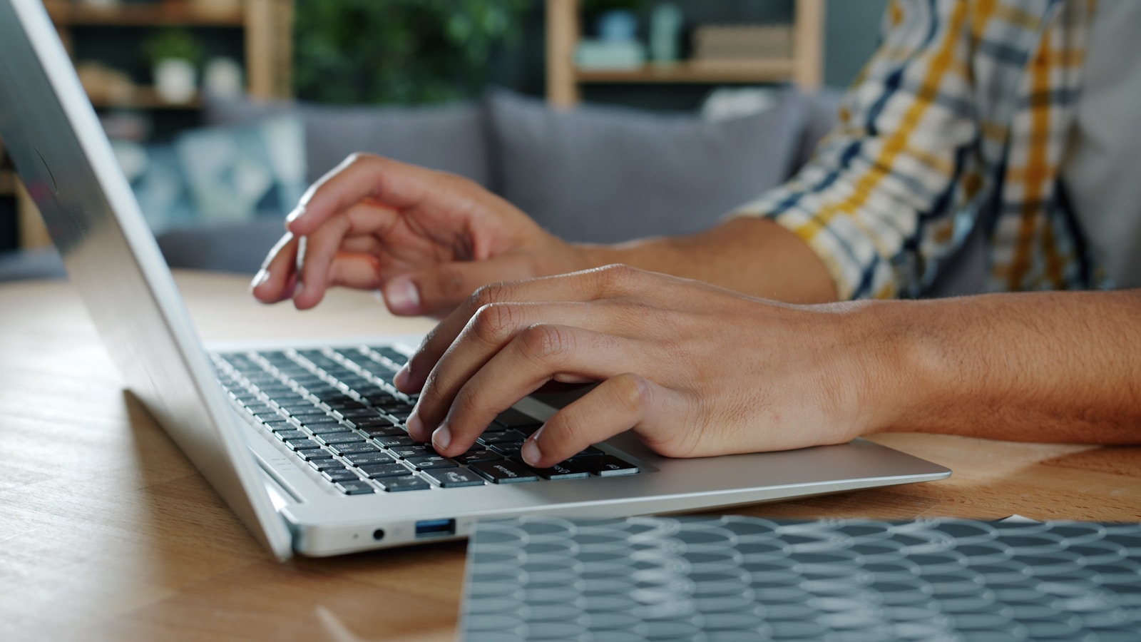 Person typing on a laptop in a workspace